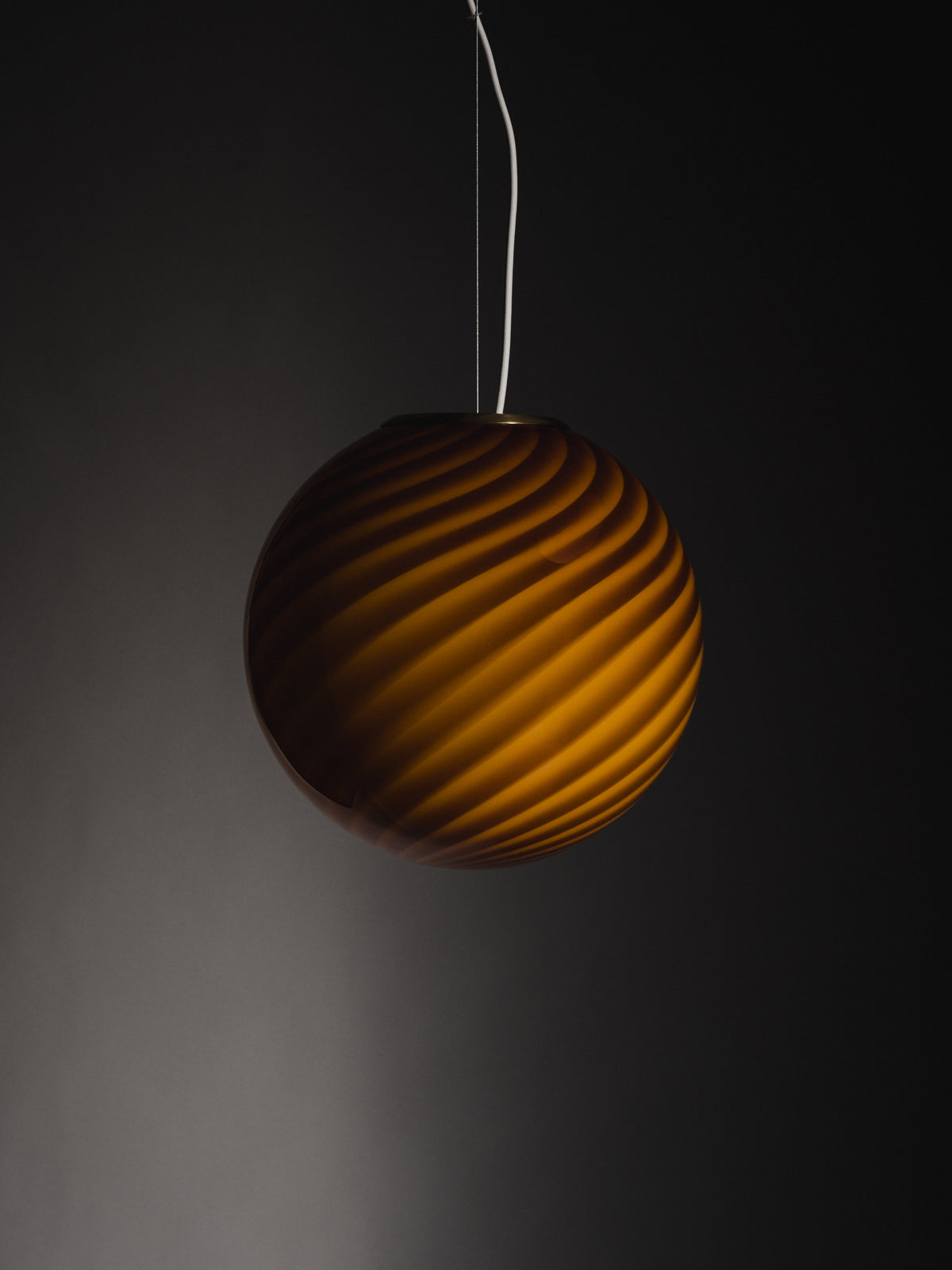 limited edition Murano Vetri glass pendant sculptural sphere-shaped pendant crafted from mouth-blown swirl opaline glass in Ambra: a bright and warm hue with golden undertones. Brass fitting hardware suspension. Murano ravgul pendel lampe I glas med swirl. Copenhagen Venice