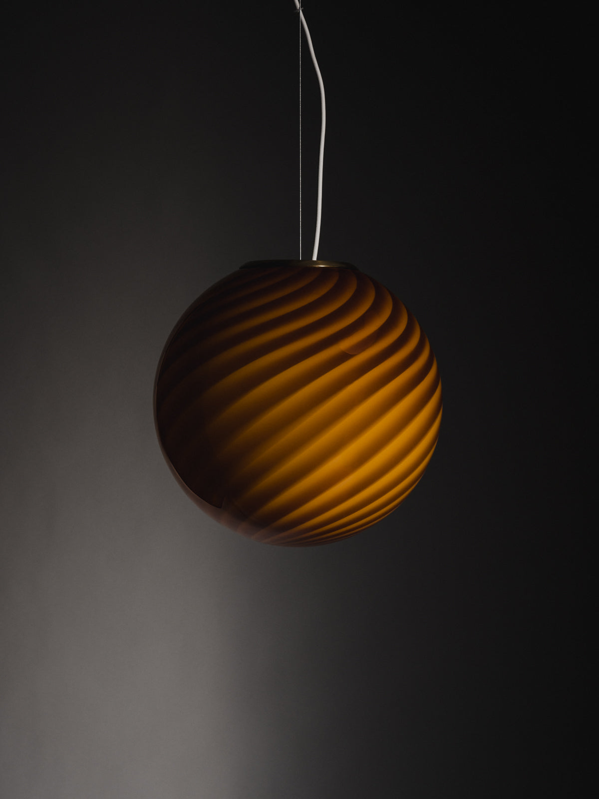 limited edition Murano Vetri glass pendant sculptural sphere-shaped pendant crafted from mouth-blown swirl opaline glass in Ambra: a bright and warm hue with golden undertones. Brass fitting hardware suspension. Murano ravgul pendel lampe I glas med swirl. Copenhagen Venice 