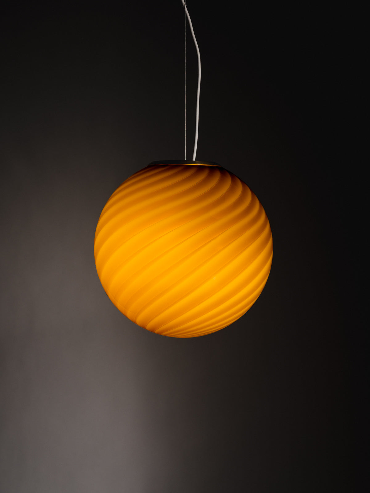 limited edition Murano Vetri glass pendant sculptural sphere-shaped pendant crafted from mouth-blown swirl opaline glass in Ambra: a bright and warm hue with golden undertones. Brass fitting hardware suspension. Murano pendel lampe I glas med swirl. Copenhagen Venice 