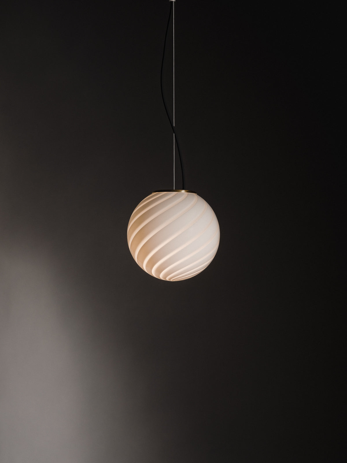 Sphere-shaped pendant lamp crafted from mouth-blown opaline glass. The design features a swirl pattern obtained using an original 1970s mould, specifically picked to give the lamp a clean expression. The piece includes a hand-casted fitting in solid brass. Handmade in Murano, Italy. Murano pendel loftslampe loftlampe Copenhagen Venice 