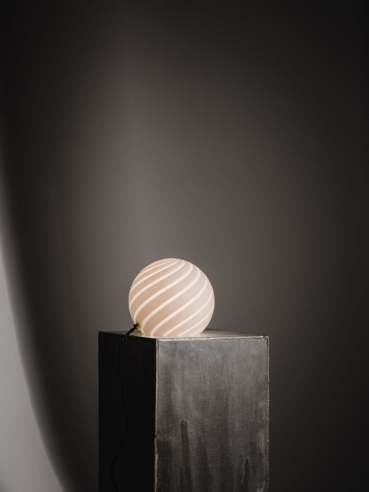 Sphere-shaped table lamp crafted from mouth-blown opaline glass. The design features a swirl pattern obtained using an original 1970s mould, specifically picked to give the lamp a clean expression. The piece includes hand-casted brass hardware.  Handmade in Murano, Italy Copenhagen Venice 