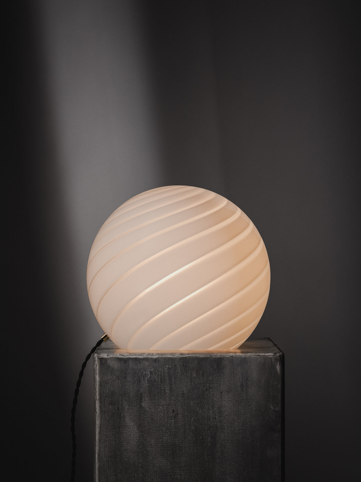Sphere-shaped table lamp crafted from mouth-blown opaline glass. The design features a swirl pattern obtained using an original 1970s mould, specifically picked to give the lamp a clean expression. The piece includes hand-casted brass hardware.  Handmade in Murano, Italy Copenhagen Venice 